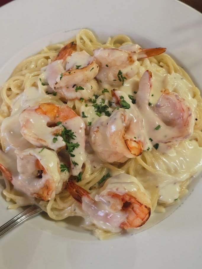 Pizza and pasta dishes on casual restaurant tables.